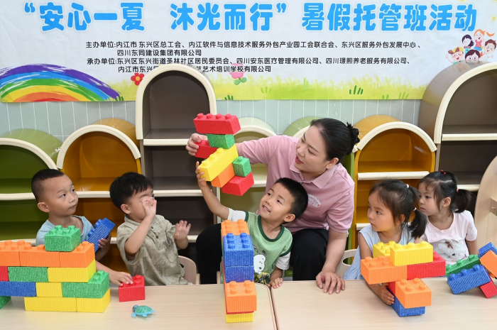 志愿者陪同孩子们玩益智游戏（兰自涛 摄）.png