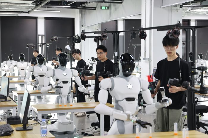 西南具身智能训练中心二期基地内，数据采集员训练机器人抓取物品 罗友莉 摄